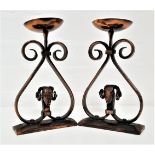 PAIR OF BRUCE WEIR WROUGHT IRON CANDLESTICKS with the holders and dished drip pans above inverted