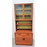 G PLAN TEAK WALL UNIT with a pair of glass doors opening to reveal shelves above an adjustable