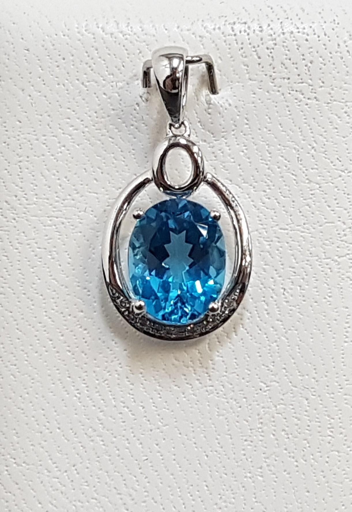 BLUE TOPAZ AND DIAMOND PENDANT the central oval cut blue topaz approximately 2.5cts with illusion