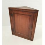 GEORGIAN OAK CORNER CABINET with a panelled door opening to reveal a shelved interior, 90.5cm high