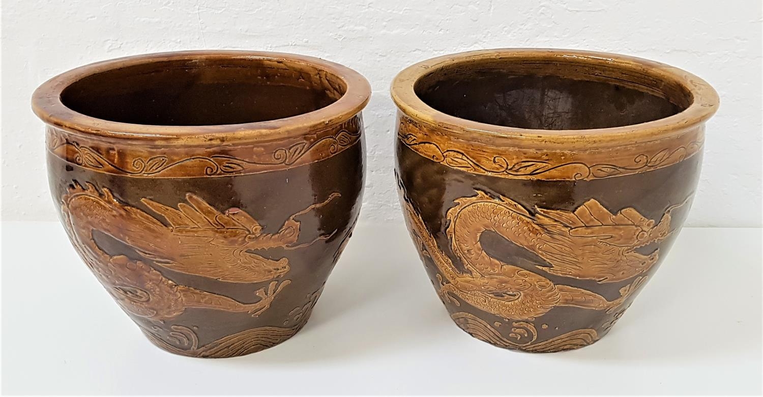 PAIR OF CHINESE POTTERY JARDINERES the brown ground decorated with dragons, 28.5cm high