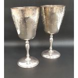 PAIR OF SILVER WINE GOBLETS each with profuse scroll decoration to the cup, standing on knopped