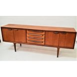 YOUNGER TEAK SIDEBOARD with a moulded top above four central drawers, one bearing a retailers