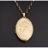 NINE CARAT GOLD OVAL LOCKET PENDANT with engraved scroll decoration, 3.9cm high including suspension