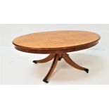 YEW WOOD OCCASIONAL TABLE with an oval tilt top, on a turned column with four outswept reeded