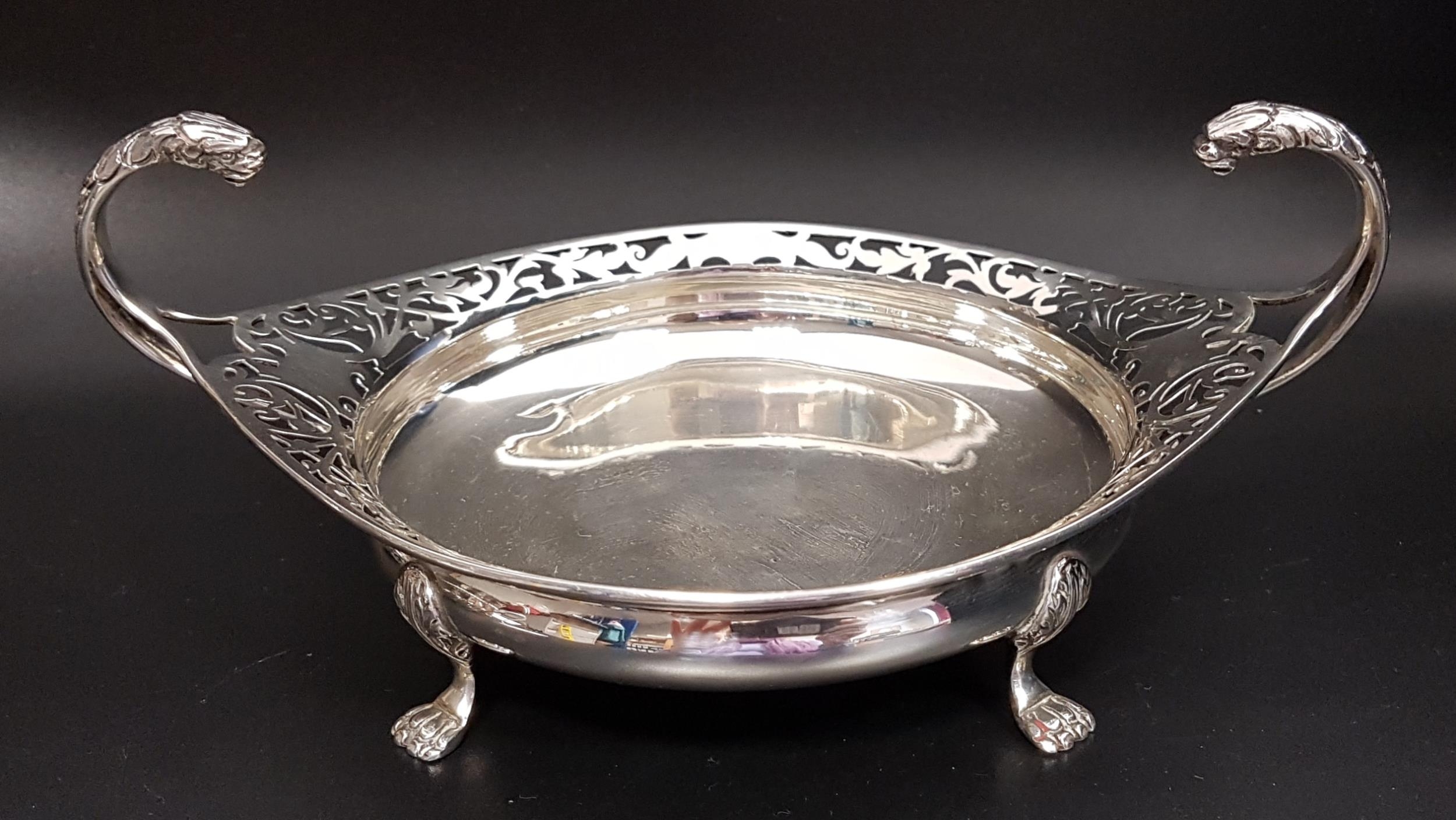 GEORGE V SILVER BON BON DISH of circular form with a pierced rim and a pair of scroll lion mask