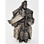 JAPANESE SILVERED BRONZE OF A SHINTO PRIEST wearing flowing robes and holding a scroll, with