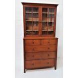 OAK BOOKCASE ON CHEST with a moulded dentil cornice above a pair of glass panelled doors opening