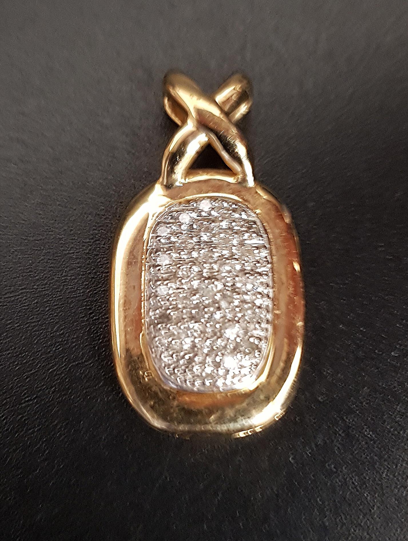 PAVE SET DIAMOND PENDANT of oval form with 'X' shaped suspension loop, in fourteen carat gold,