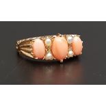 GRADUATED CORAL AND PEARL RING the three oval coral cabochons separated by seed pearls, on nine