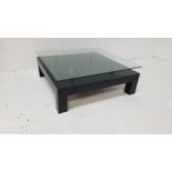 CONTEMPORARY OCCASIONAL TABLE with a floating square glass top above a stained black wood base, on