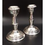 PAIR OF GEORGE V SILVER CHAMBER STICKS raised on circular loaded bases with turned shaped columns,