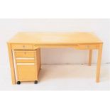 BEECH DESK with a central pull out slide flanked by a pair of drawers, standing on plain supports,