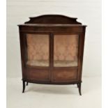 BOW FRONT MAHOGANY DISPLAY CABINET with a shaped raised back above a moulded top, the part glazed