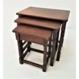 NEST OF OAK OCCASIONAL TABLES with rectangular tops, standing on turned supports united by a