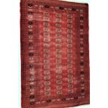 BOKHARA RUG with a deep red ground, the central section with geometric motifs, encased by a multi