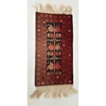 BELOUCH RUG the central blue ground with geometric motifs, encased by a layered red border, fringed,