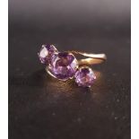 ATTRACTIVE AMETHYST THREE STONE RING in twist setting, the central round cut amethyst