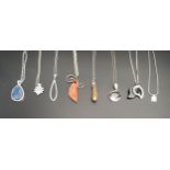EIGHT SILVER AND SILVER MOUNTED PENDANTS including amber and agate set examples and an opal set