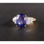 TANZANITE AND DIAMOND RING the central oval cut tanzanite approximately 3.4cts, flanked by three