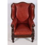 A 19TH CENTURY MAHOGANY AND HIDE UPHOLSTERED LIBRARY WING CHAIR the shaped top rail with upholstered