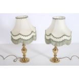 A PAIR OF BRASS TABLE LAMPS each with a faceted column above an octagonal spreading foot with shades