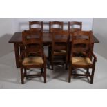 A TEN PIECE OAK REFECTORY DINING ROOM SUITE comprising eight ladder back chairs including a pair