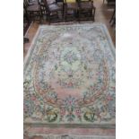 AN INDIAN WOOL RUG the light pink and beige ground with overall floral decoration within a plain