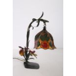 A TIFFANY DESIGN WROUGHT IRON TABLE LAMP with multicoloured glass shade and scroll arm with