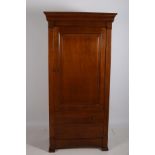 A CHERRYWOOD CUPBOARD the outswept moulded cornice above a panelled door containing adjustable