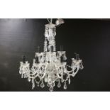 A TWELVE BRANCH CHANDELIER in two registers hung with faceted chains and pendent drops 75cm (d) x
