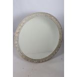 A GREY PAINTED MIRROR the circular plate within an acorn foliate carved frame with strapwork