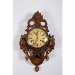 A STAINED WOOD CAROUSEL WALL CLOCK decorated with flowerheads swags and ribbon tied cresting the