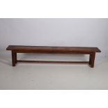 A STAINED OAK BENCH of rectangular outline on square moulded legs joined by a cross stretcher