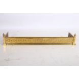 AN ADAMS DESIGN BRASS FENDER with embossed frieze between rectangular columns with urn capitals 21cm