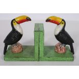 A PAIR OF CAST METAL AND POLYCHROME BOOKENDS each modelled as a toucan shown standing on a