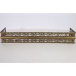 A 19TH CENTURY PIERCED BRASS FENDER gadrooned top rail base 19cm (h) x 115cm (w) x 29cm (d)