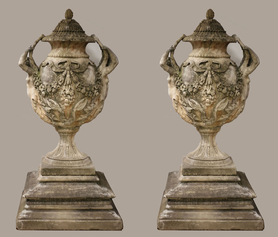 A VERY FINE AND IMPRESSIVE PAIR OF SANDSTONE URNS each of ovoid tapering form hung with ribbon