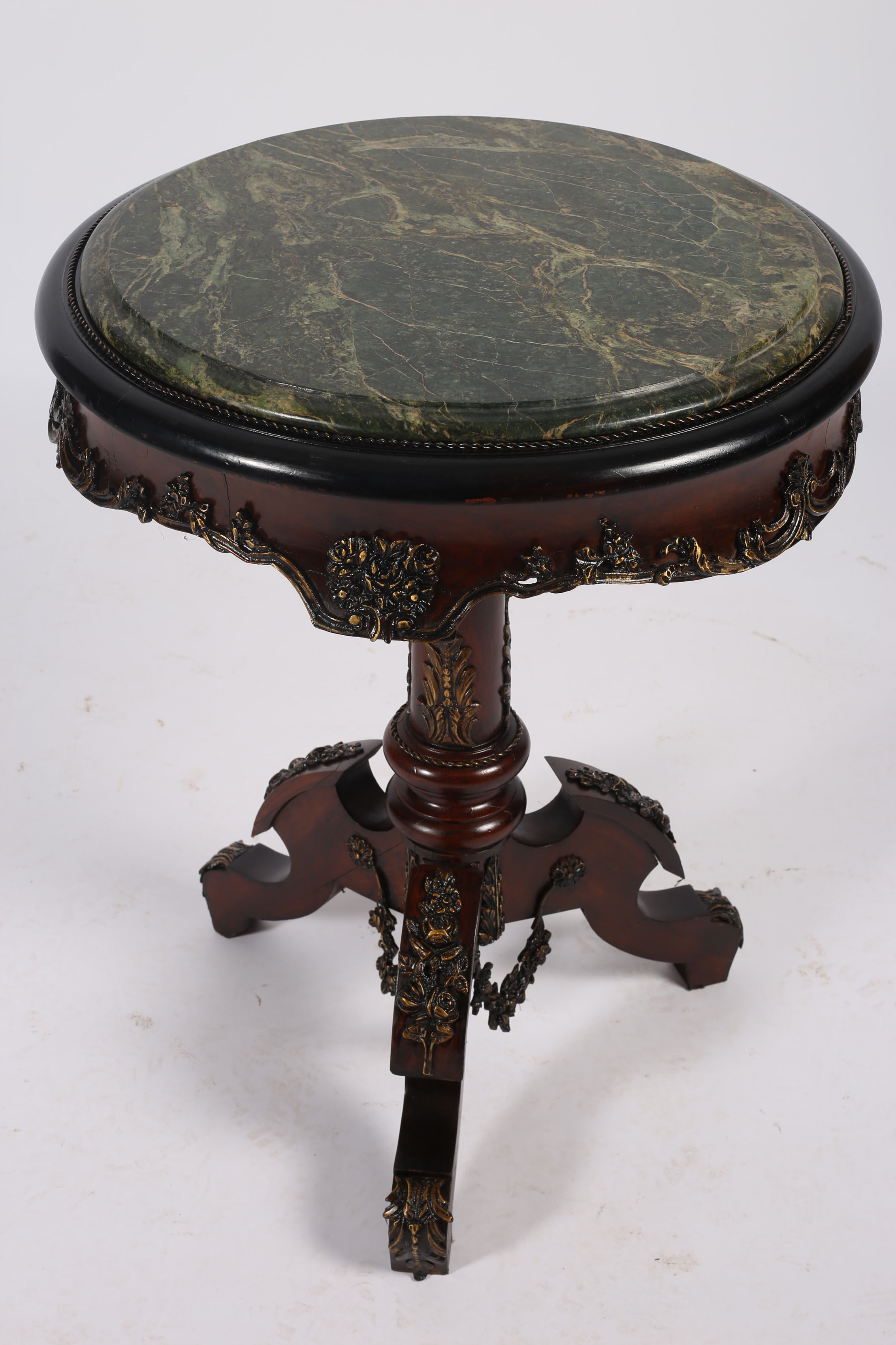 A CONTINENTAL MAHOGANY AND GILT BRASS MOUNTED TABLE of cylindrical outline surmounted by a green