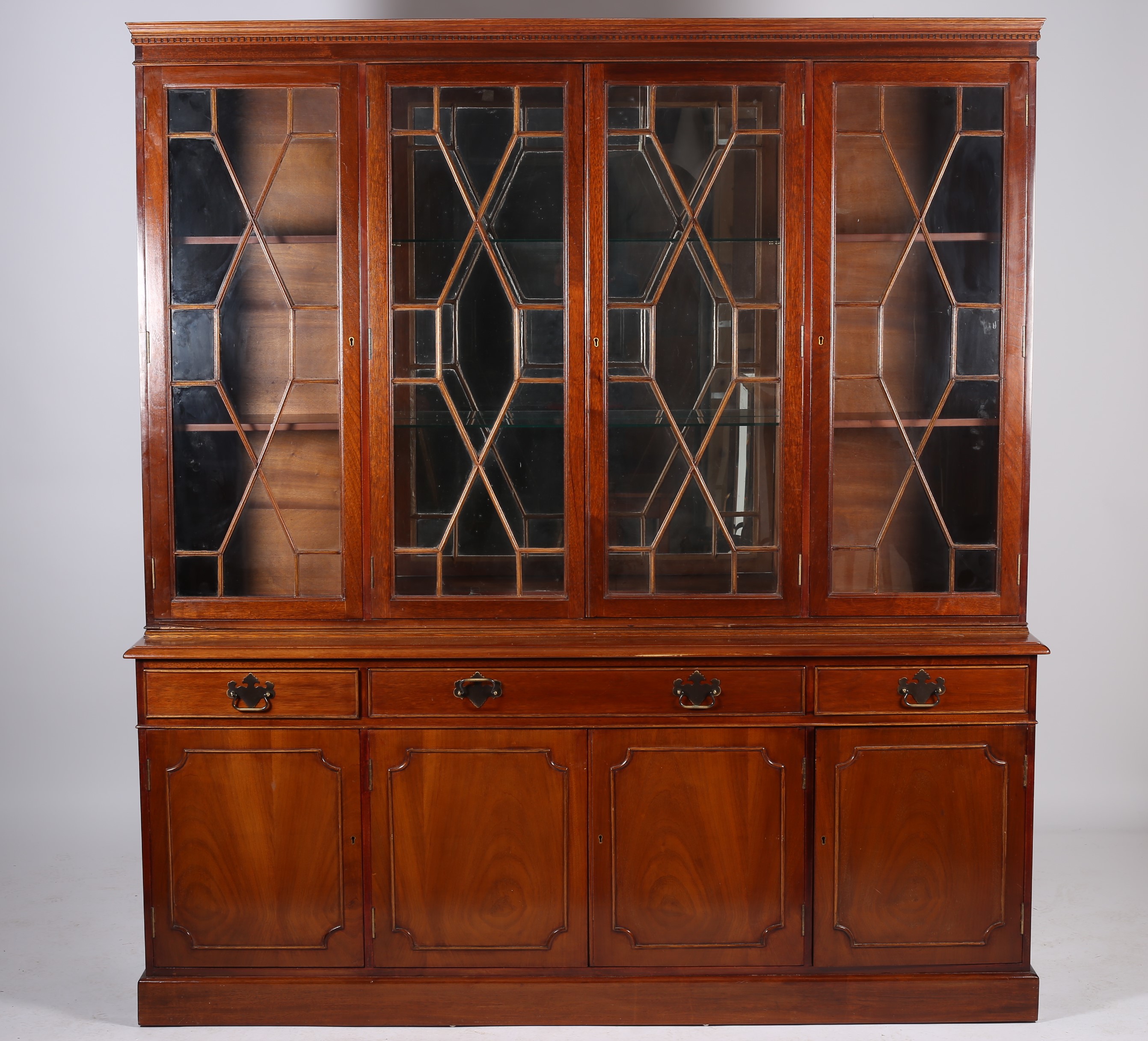 A GEORGIAN DESIGN MAHOGANY FOUR DOOR LIBRARY BOOKCASE the dentil moulded cornice above astragal