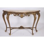 A CONTINENTAL GILTWOOD AND GESSO CONSOLE TABLE of serpentine outline surmounted by a veined marble