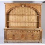 A LARGE PINE OPEN FRONT DRESSER the dentil moulded cornice centred by a figural mask with