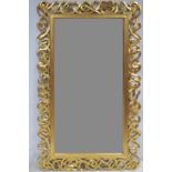 A CONTINENTAL GILT FRAMED MIRROR the rectangular bevelled glass plate within a pierced intertwined