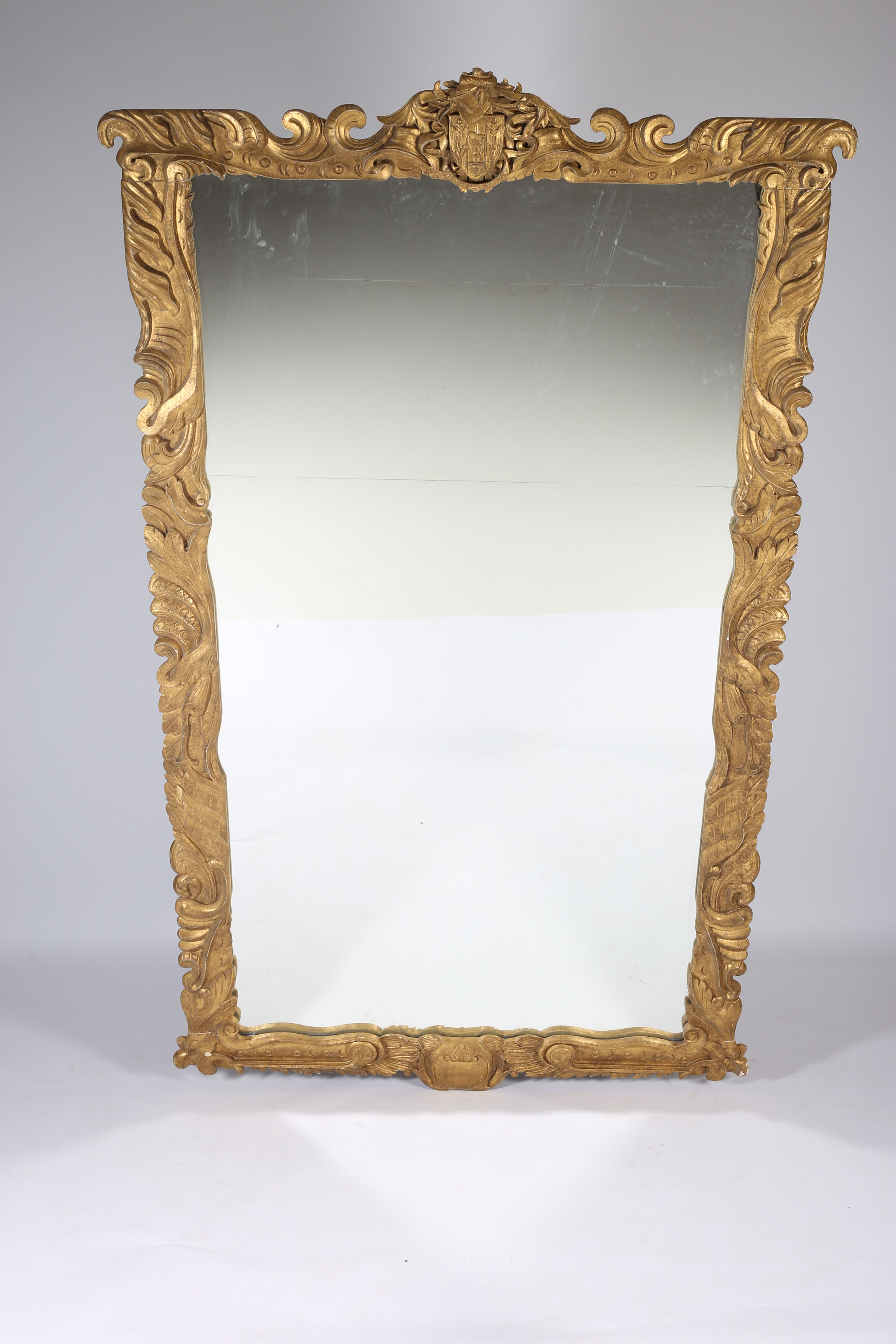 A CONTINENTAL GILT FRAMED MIRROR the rectangular plate within a foliate and C-scroll carved frame