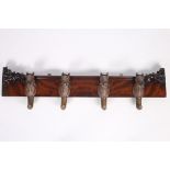 A 19TH CENTURY CARVED MAHOGANY WALL MOUNTED COAT HANGER with later horse head hooks 26cm x 104cm