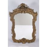 A CONTINENTAL GILTWOOD AND GESSO MIRROR the shaped plate within a flowerhead foliate and C-scroll