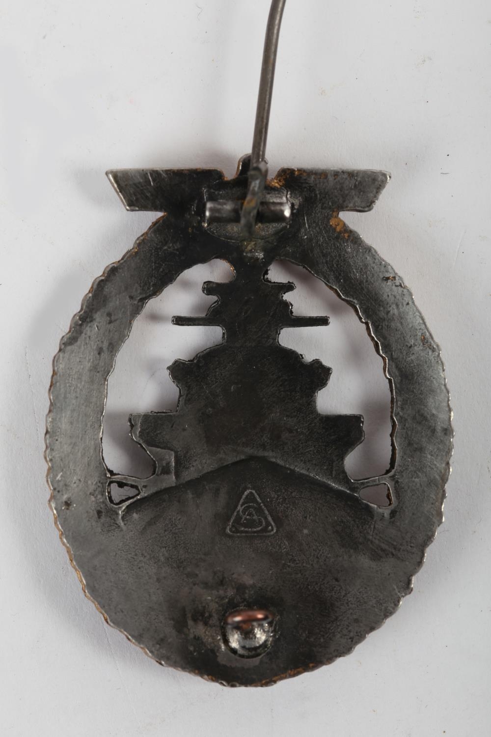 1939-1945 German Kriegsmarine high seas fleet badge. A grey approaching battleship within a gilt - Image 2 of 2