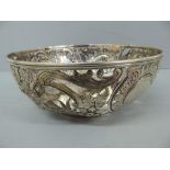 An Edwardian chased and pierced silver fruit bowl with decoration of figure, flora fauna and