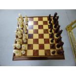 Walnut games table with composite figure chess pieces and revealing baize backgammon board when