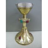 Arts and Crafts communion chalice in chased brass, set with hard stones having a silver plated bowl.